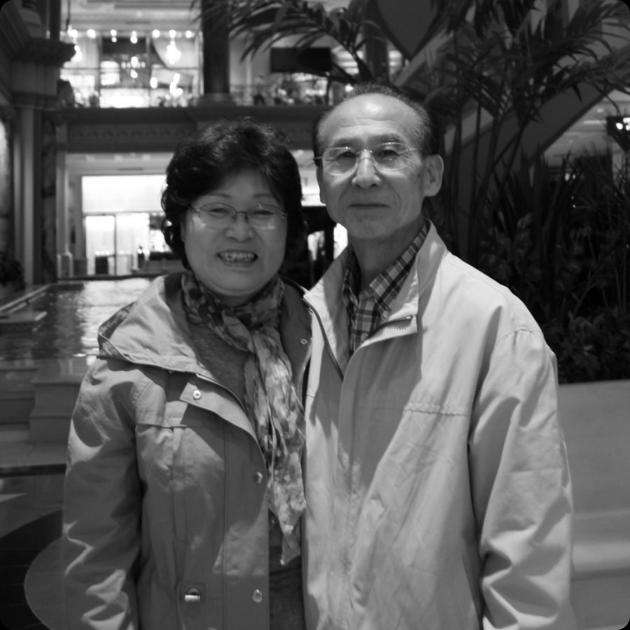 Hasoo Jung and Namjin Lee, elderly couple founders of Team Boaz, formal portrait in warm indoor setting