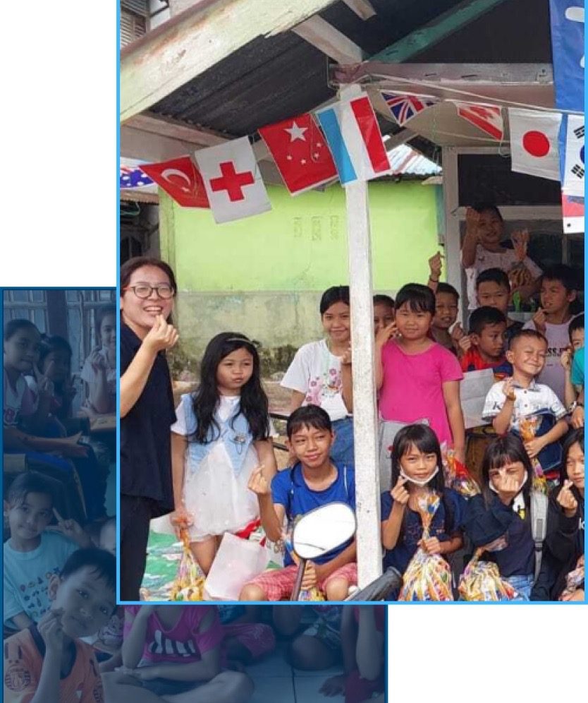 Team Boaz volunteers and children in a bright indoor community space, warm community gathering